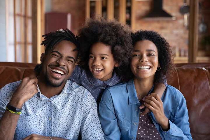 Image of a dad, child, and mom smiling